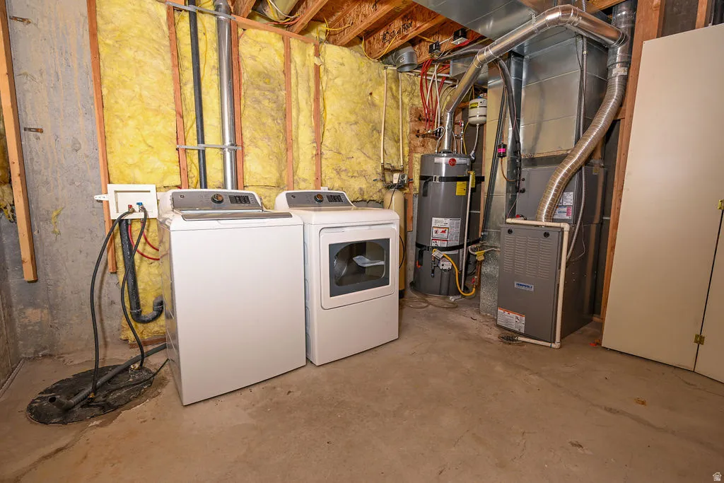 Laundry area with concrete flooring, exposed ceiling joists, and insulated wall framing