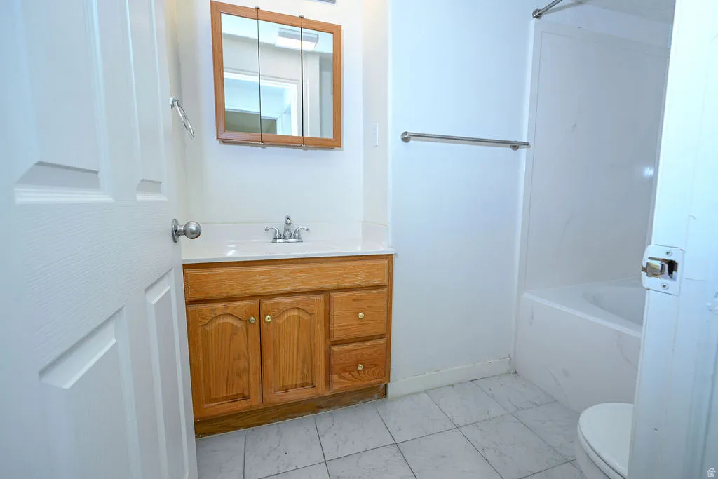Wood-finish vanity with a white countertop and integrated sink