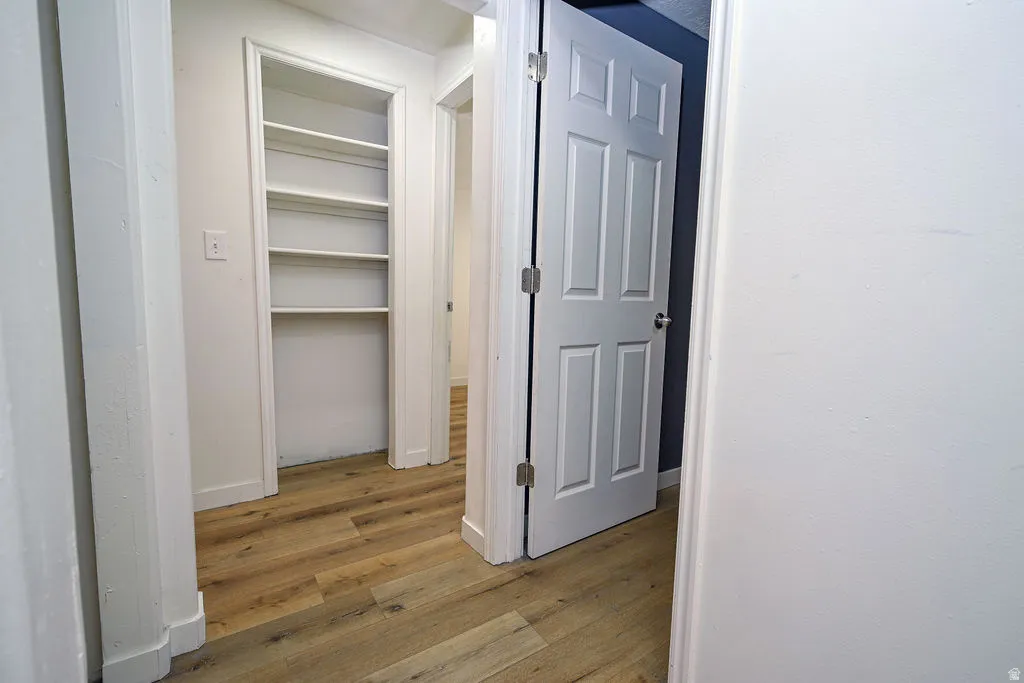Wood-finish flooring throughout, white interior walls, and built-in shelving