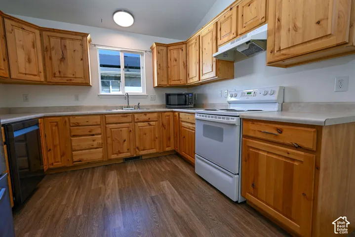 Kitchen featuring wood-finish cabinetry, light-toned countertops, and wood-finish flooring
