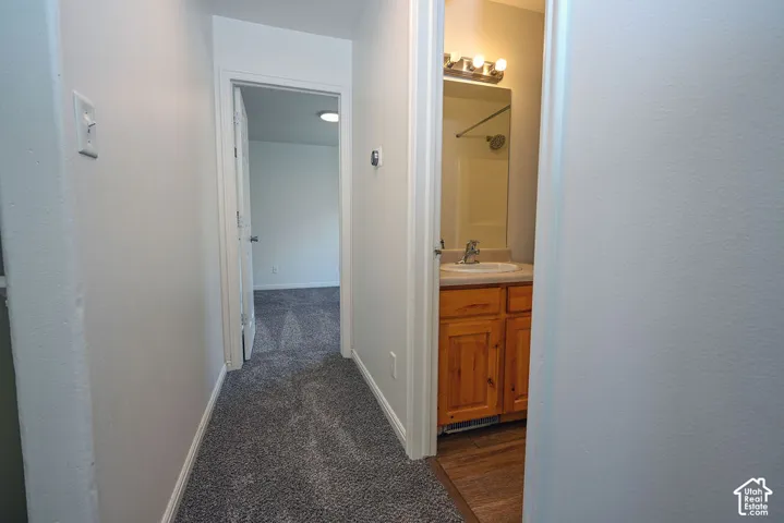 Hallway with neutral carpeting and light-toned walls