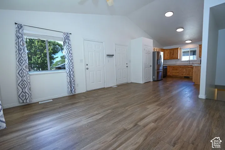 Vaulted ceilings, wood-finish flooring, recessed lighting, wood cabinetry, and stainless steel appliances