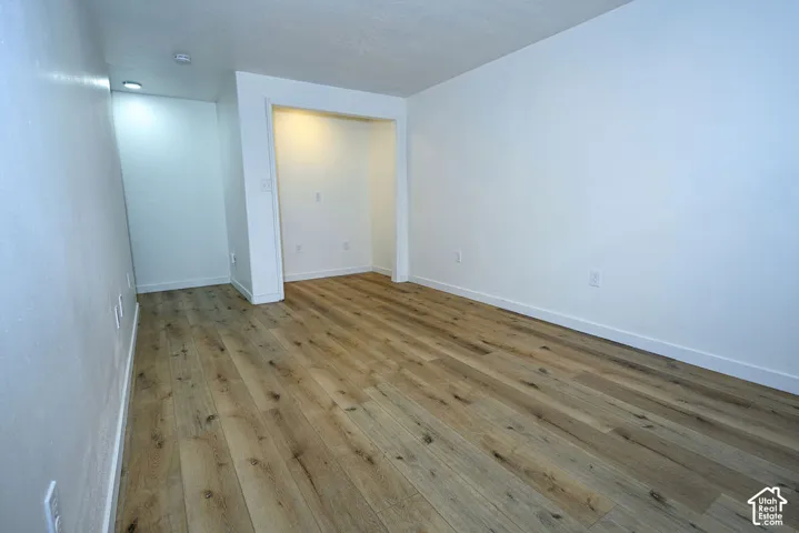 Wood-finish flooring throughout, recessed lighting, and a built-in alcove feature