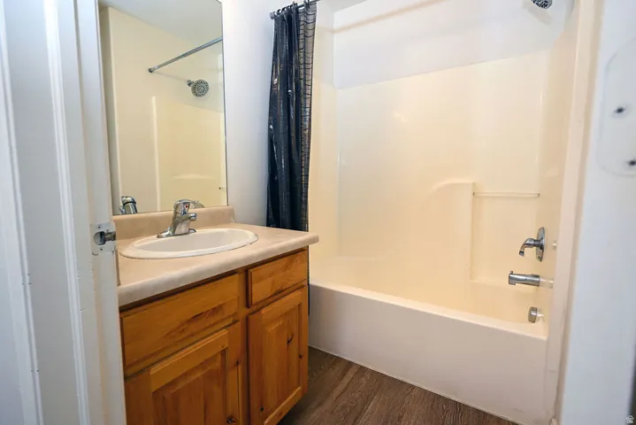 Single vanity with an integrated sink, wood-finish cabinetry, and a chrome faucet