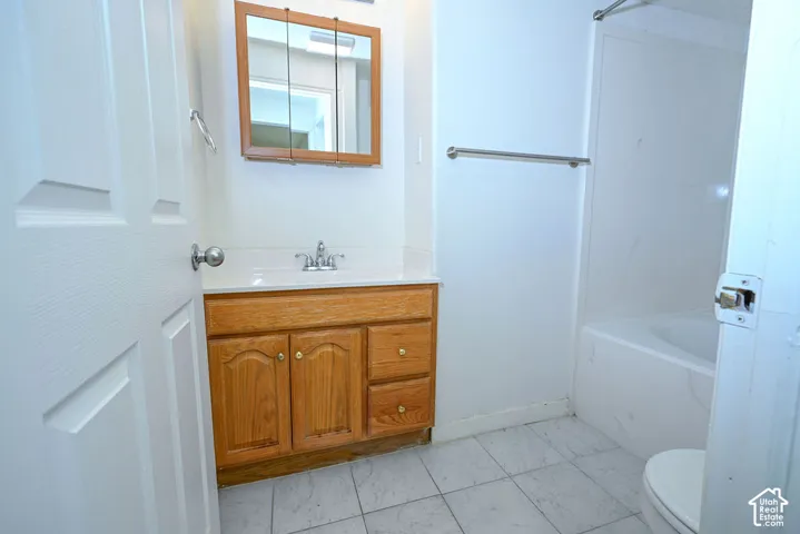 Wood-finish vanity with a white countertop and integrated sink