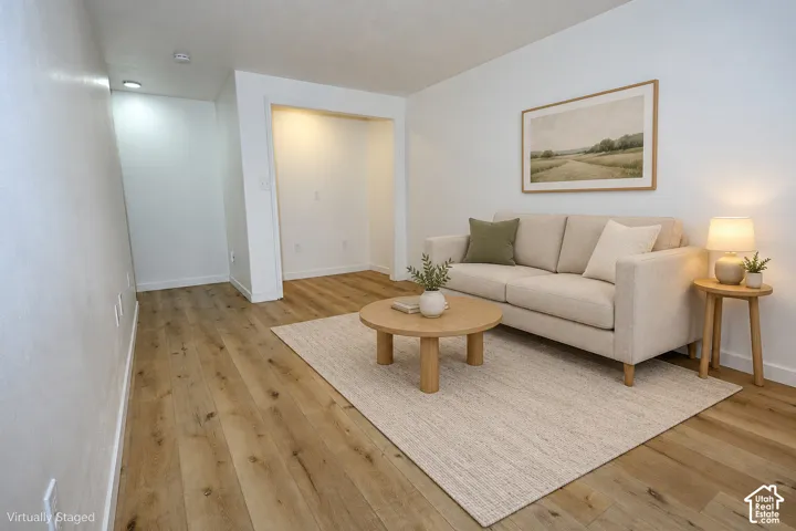 Living area featuring wood-finish flooring, recessed ceiling lighting, and a recessed alcove