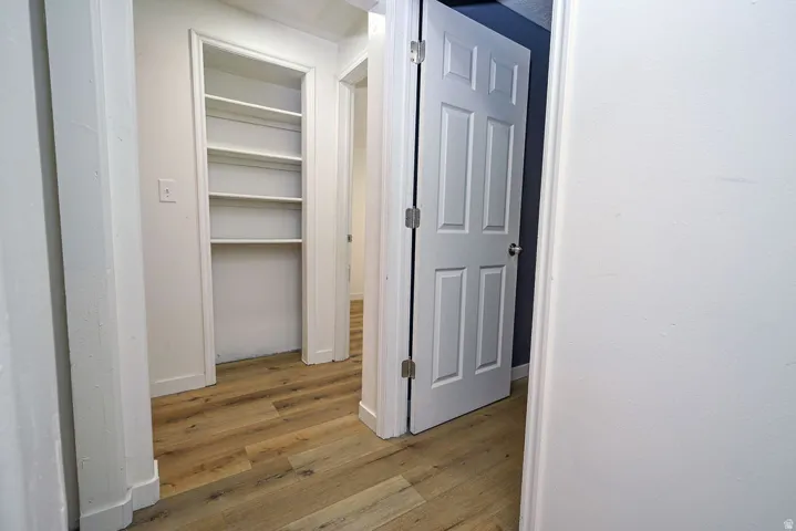Wood-finish flooring throughout, white interior walls, and built-in shelving