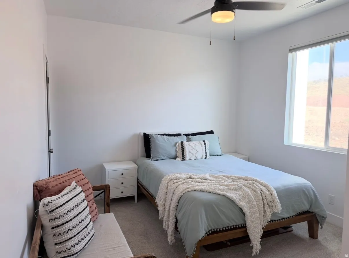 Neutral wall finishes, recessed window, dark ceiling fan, and carpeted flooring