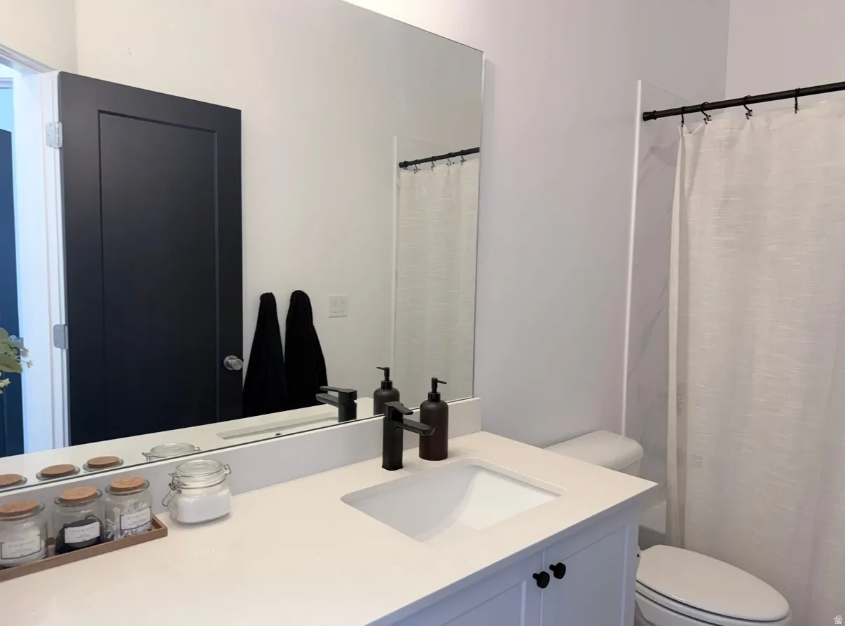 Vanity with a rectangular undermount sink, matte black faucet, and white countertop
