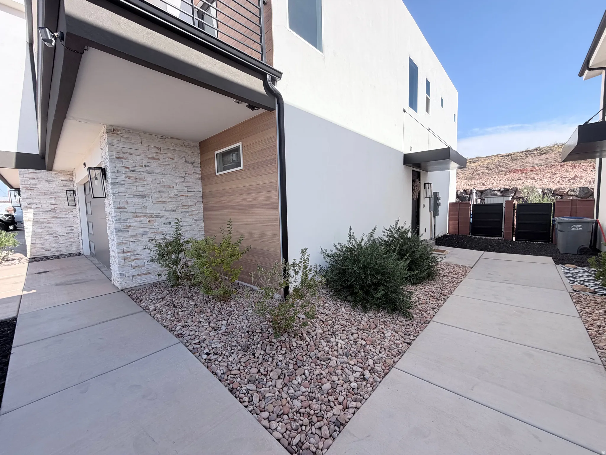 Modern exterior with stacked stone and wood-finish siding accents