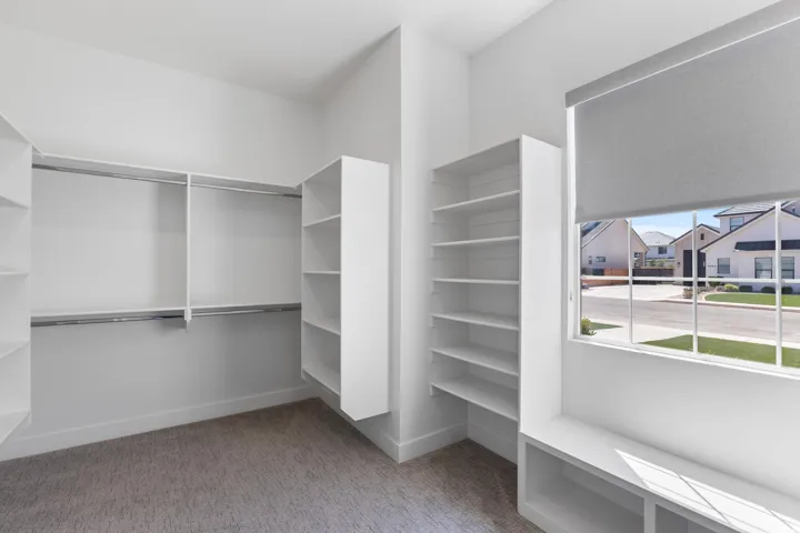 Built-in shelving, hanging rods, an integrated window bench, and a roller shade