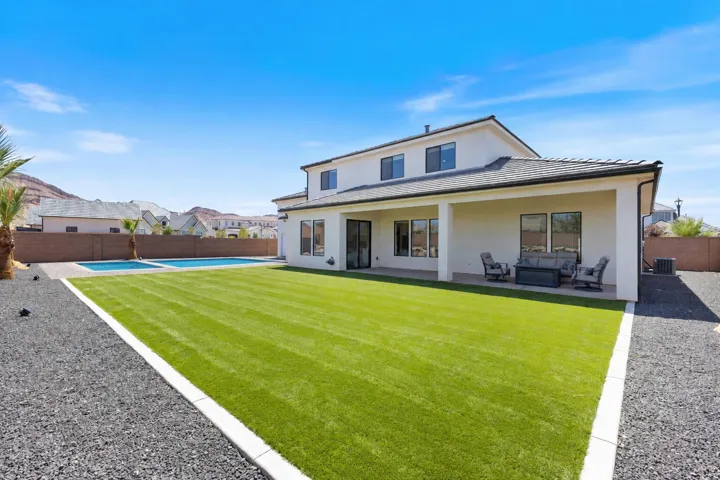 Expansive backyard featuring a professionally manicured lawn with crisp white border edging and mature landscaping