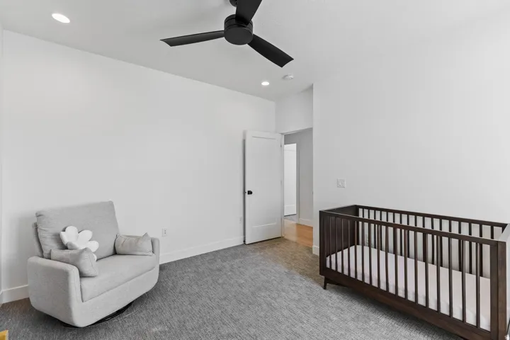 Bright nursery with hardwood flooring, recessed ceiling lighting, and a ceiling fan