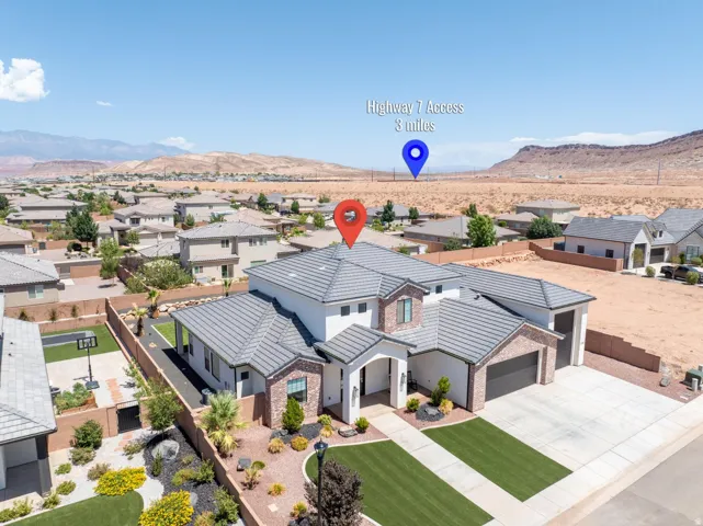 Modern architectural residence featuring a striking metal roof with clean geometric lines, expansive front-facing driveway with concrete paving, manicured front lawn with mature landscaping, and a multi-garage structure