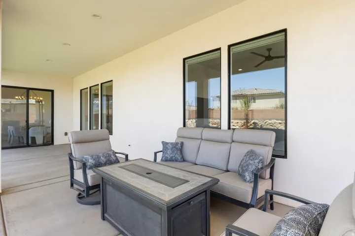 Covered patio with recessed lighting, concrete flooring, and multiple large windows with dark frames