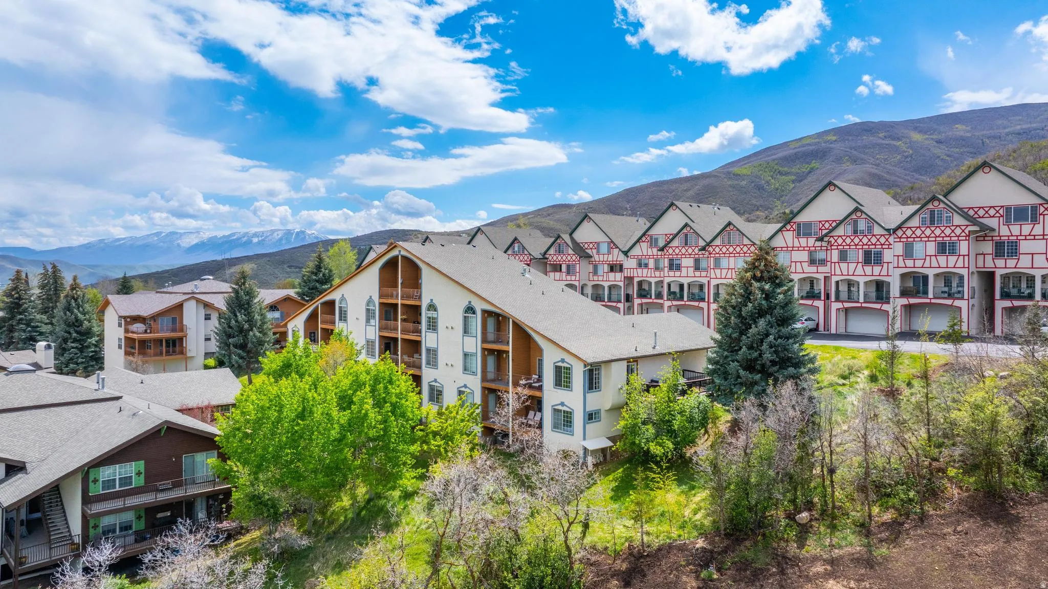 Multiple buildings featuring varied architectural styles and prominent mountain ranges
