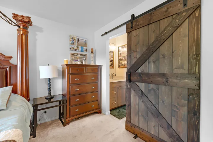 Barn door entry to bathroom with vanity and integrated sink