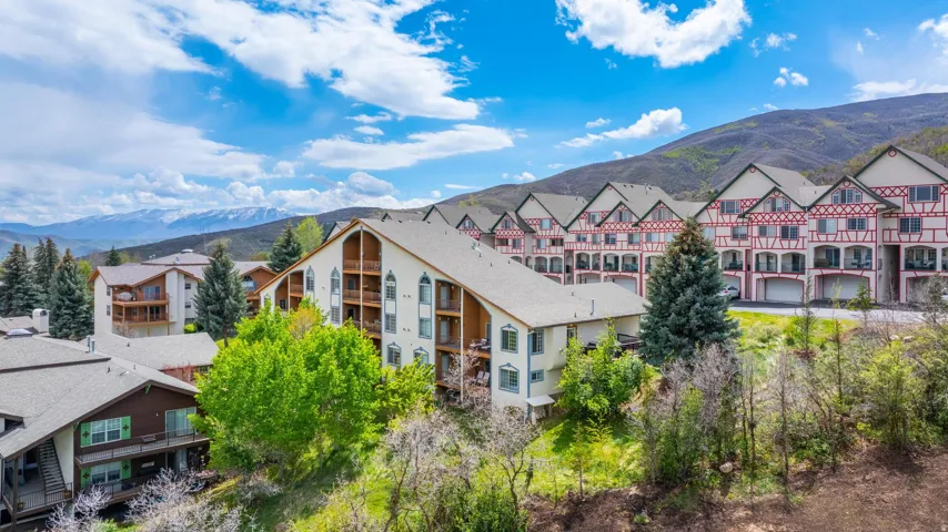 Multiple buildings featuring varied architectural styles and prominent mountain ranges