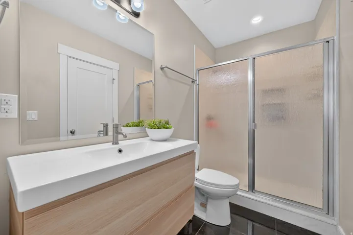 Floating vanity with a light wood-finish, integrated sink, and brushed nickel faucet
