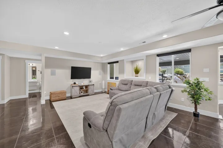Recessed lighting illuminates the living area with dark tile flooring