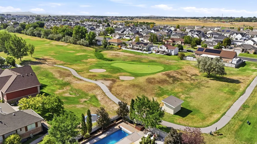 Expansive property with a private swimming pool, mature landscaping, and an adjacent golf course