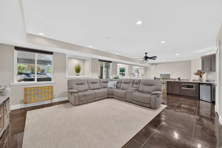 Expansive open-concept room featuring high ceilings, recessed lighting, and large format polished floor tiles