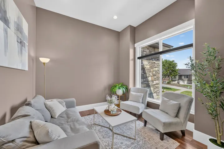 Hardwood-finish flooring, recessed lighting, and a large window with black roller shades