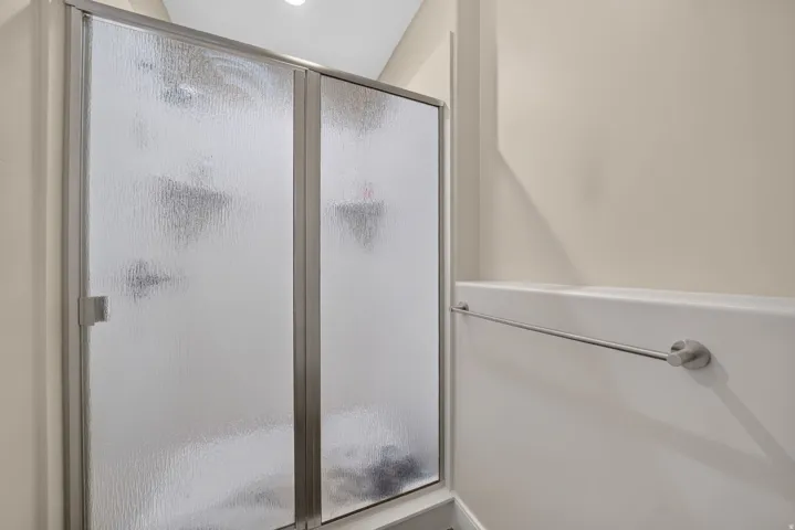 Textured glass shower enclosure with brushed nickel hardware