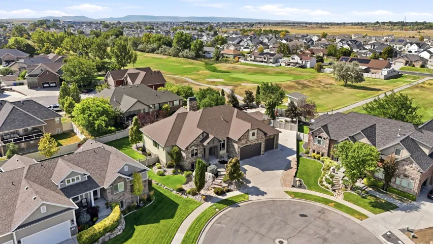 Expansive residential property with a multi-gabled roof, stone and stucco exterior, and an attached three-car garage