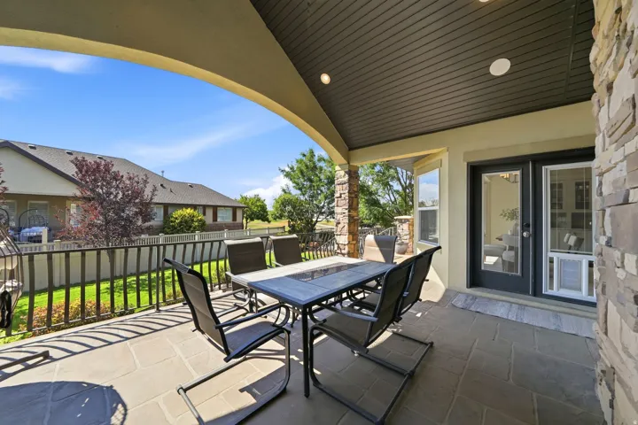Covered patio with stone-look tile flooring, recessed lighting, and a dark wood-finish ceiling