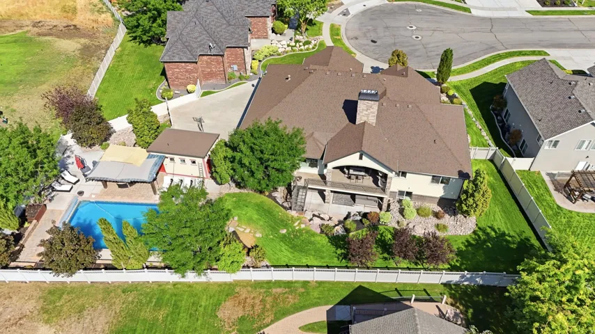 Expansive lot featuring a large private pool, mature landscaping, and a multi-level deck