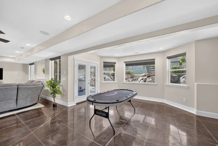 Spacious lower level featuring large format tile flooring, recessed lighting, and multiple windows