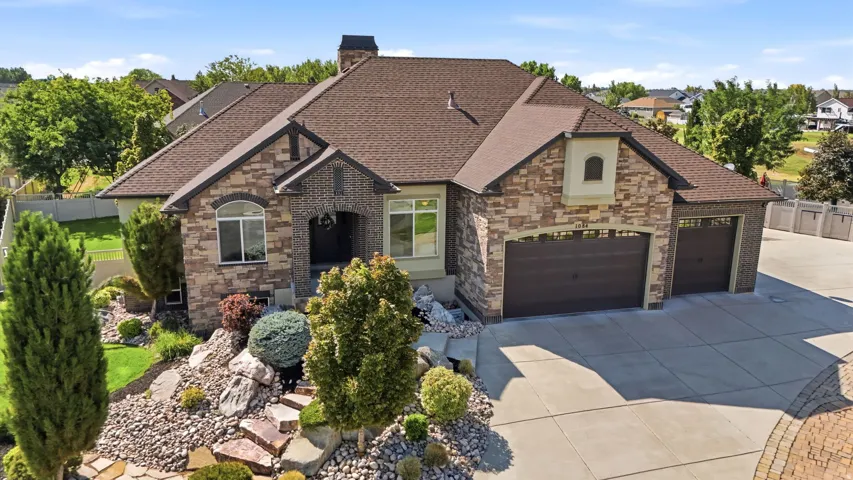 Stone and brick exterior with a brown shingle roof
