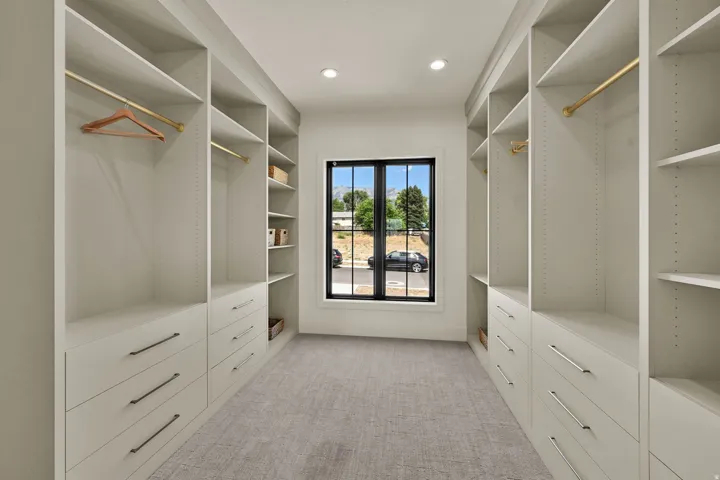 Custom closet system featuring built-in shelving, drawers with modern hardware, and hanging rods