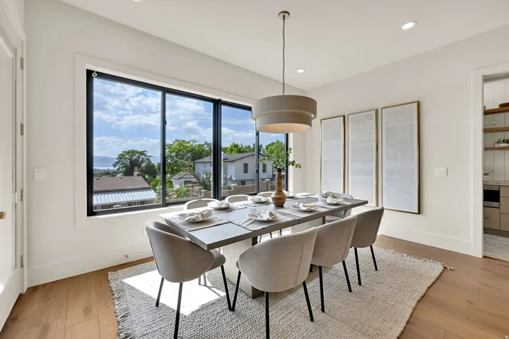 Spacious room featuring a large window, recessed lighting, and wood-finish flooring