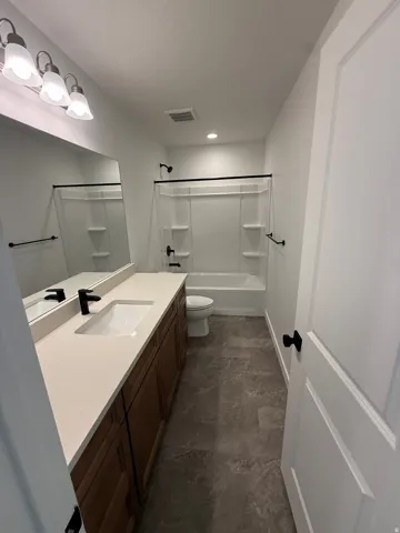 White vanity with wood-finish cabinetry and a single sink