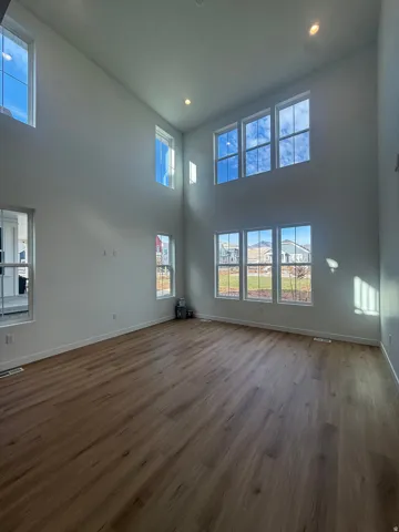 High ceilings, recessed lighting, wood-finish flooring, and multiple large windows