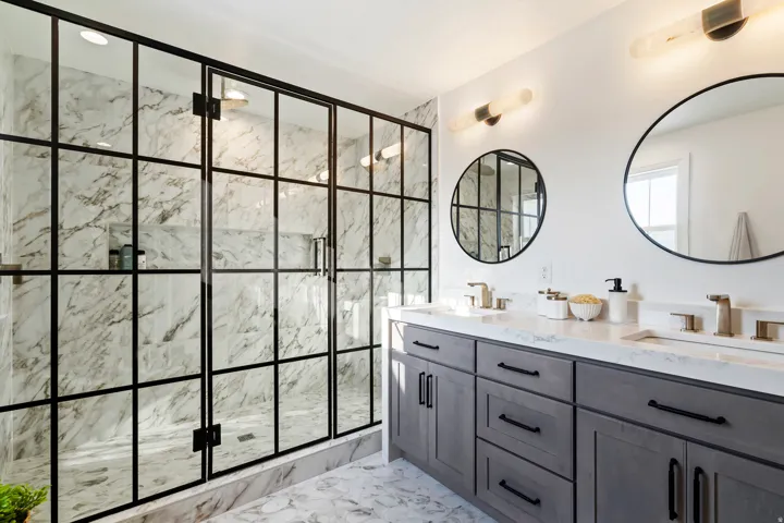 Dual vanity with undermount sinks, stone countertops, and brass-tone fixtures