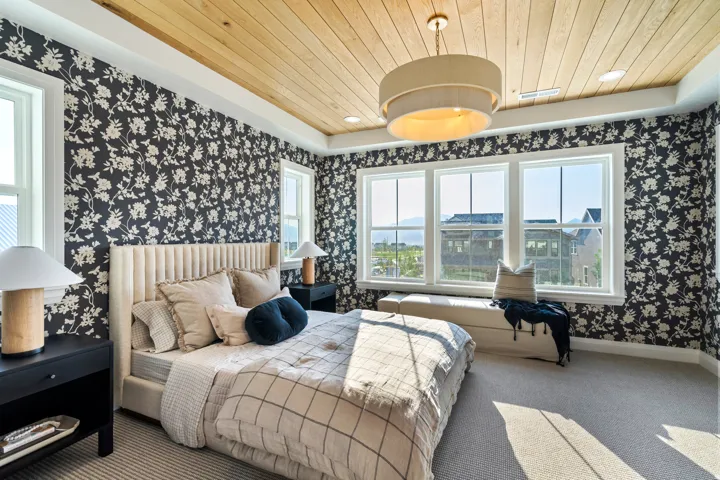 Wood-plank ceiling, patterned wallpaper, recessed lighting, carpeted flooring, and a large window with a built-in window seat