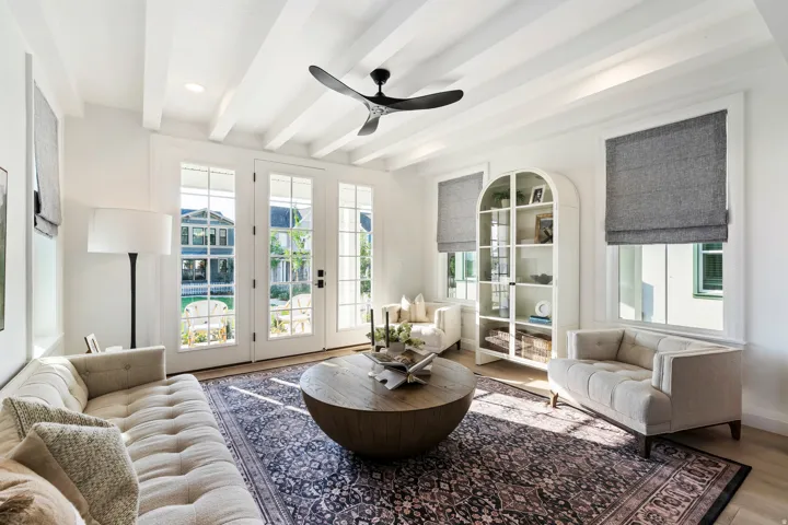 White wood-beam ceiling with a contemporary black ceiling fan