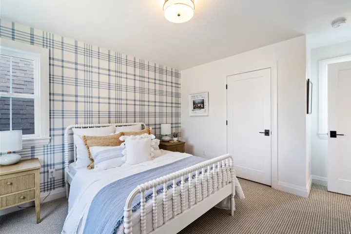 Plank wallpaper accent wall, white trim window, neutral patterned carpet, white doors with matte black hardware, and a flush mount ceiling light