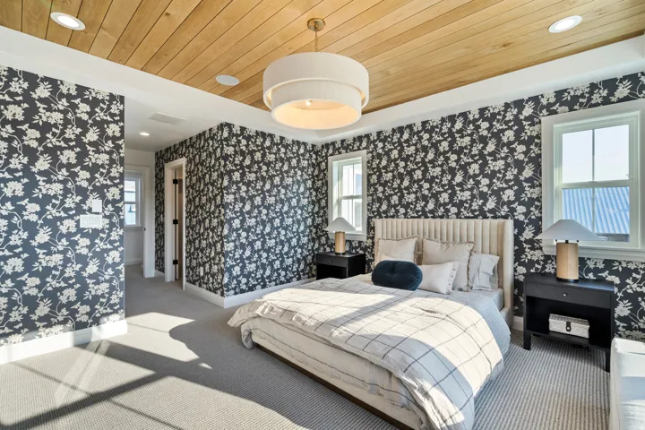 Wood-plank ceiling with a flush-mount light fixture, recessed lighting, and patterned wallpaper