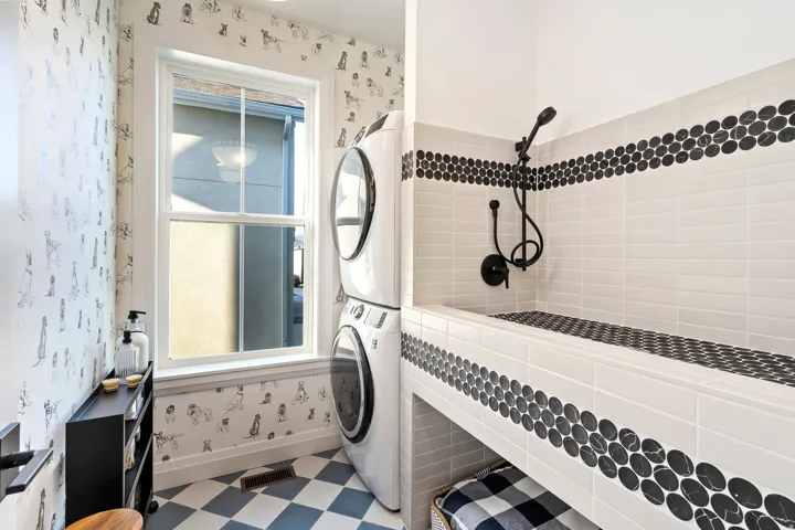 Built-in utility shower with black penny round tile accents and matte black fixtures