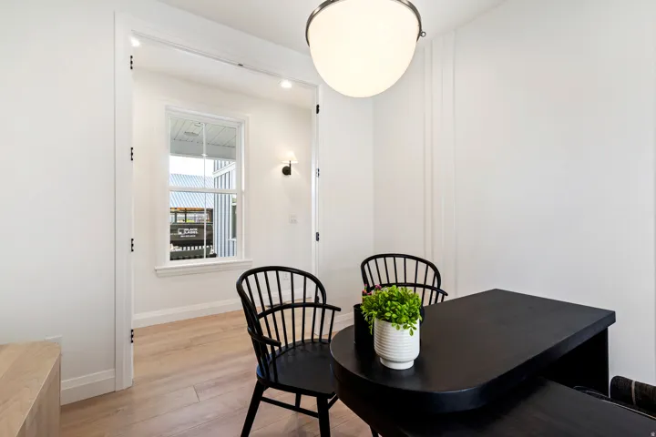 Wood-finish flooring with white walls and trim, accented by a modern wall sconce and spherical ceiling fixture