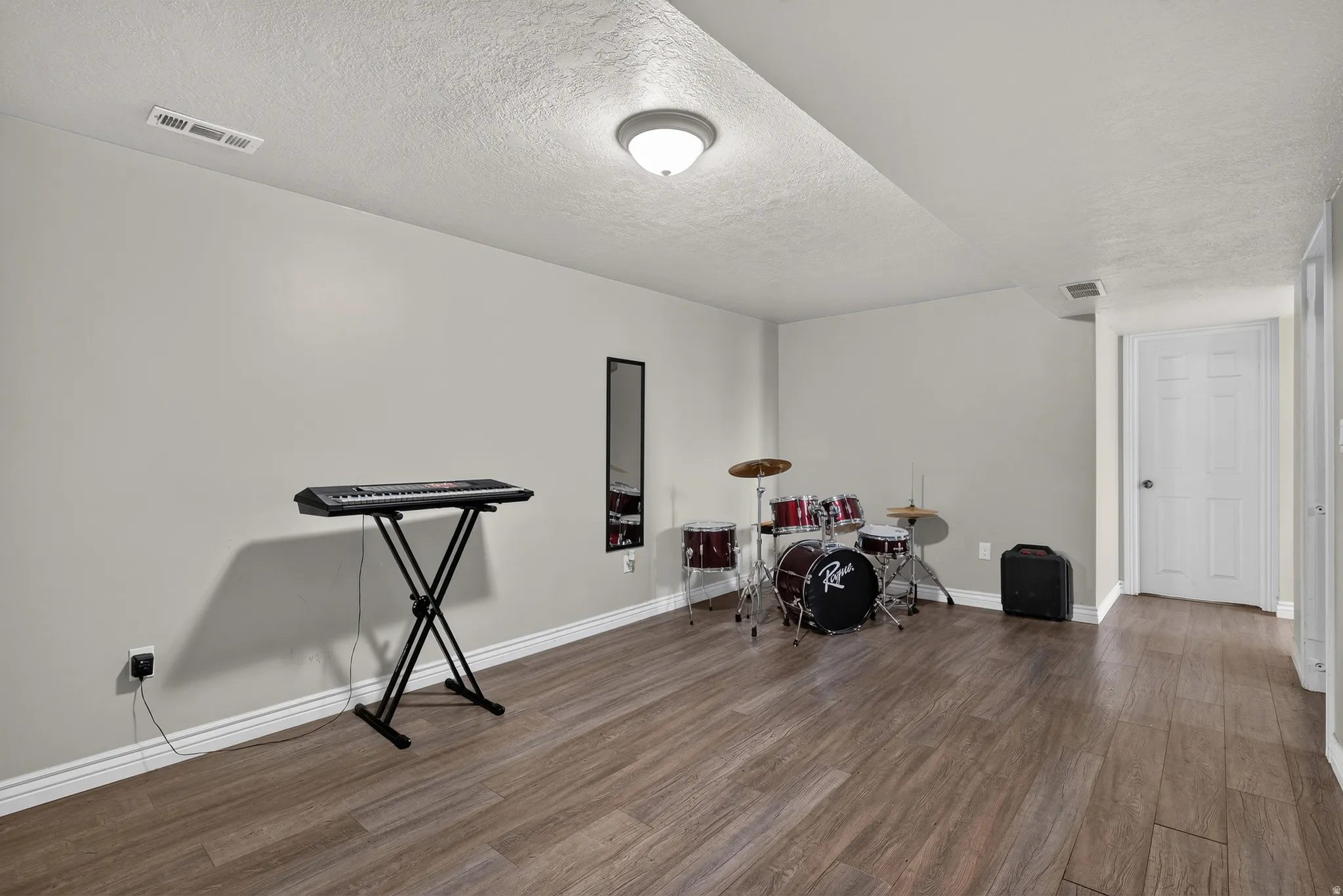 Wood-finish flooring, recessed ceiling, white interior door, and light gray wall finish