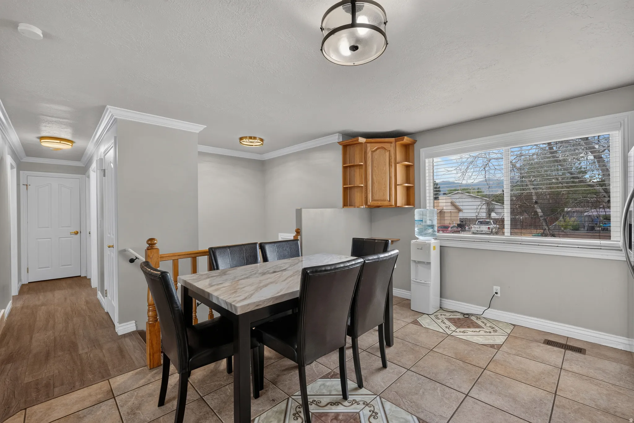 Recessed wood-finish cabinetry, tile flooring, wood-finish flooring, white window frame, and wood-finish handrail