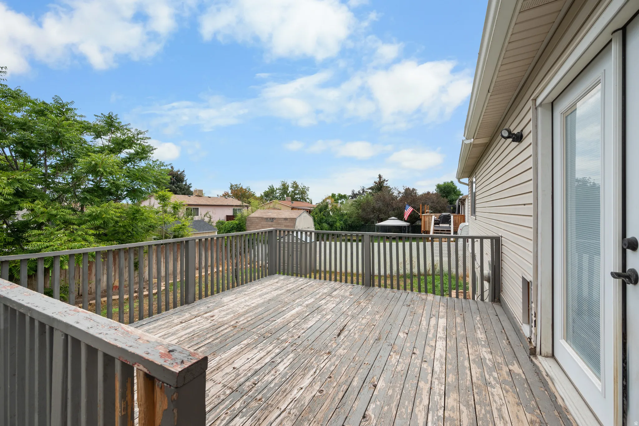 Spacious wood deck with perimeter railing and direct access via a glass-paneled door