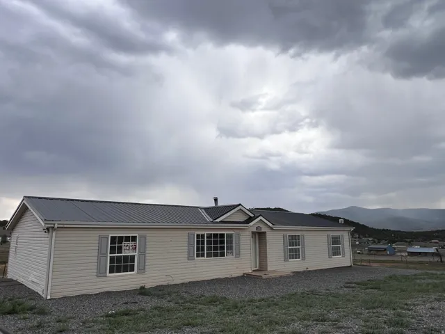 Light-toned siding exterior with a dark metal roof