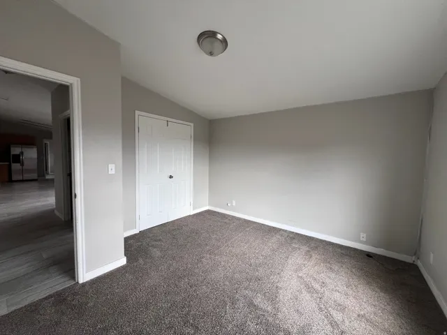 Plush carpet flooring, neutral wall tones, white trim, and a ceiling-mounted light fixture