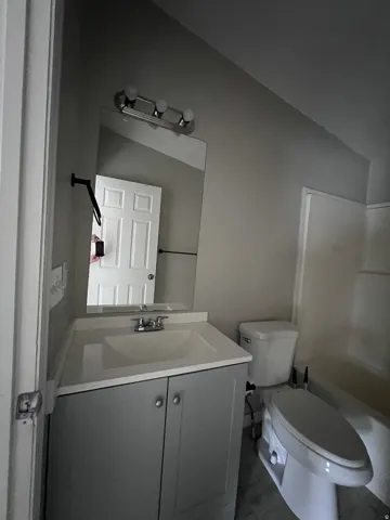 Vanity with integrated sink, chrome faucet, and storage cabinetry